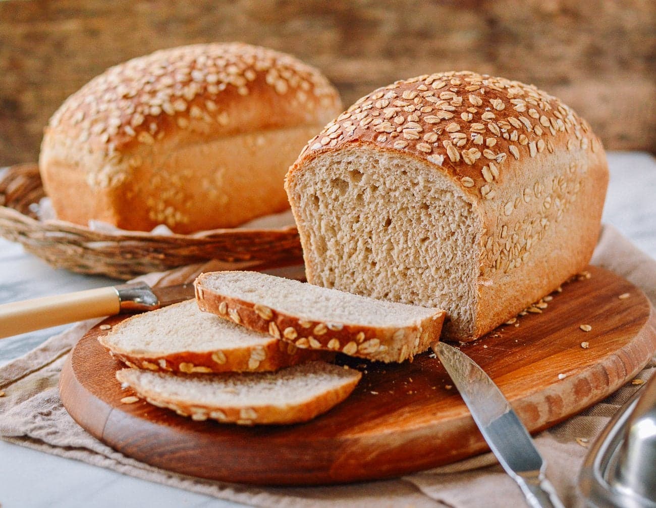 Country hearth multigrain bread loaf sliced on wooden cutting board